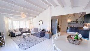 A spacious living room with a sofa set, a dining table, and a kitchen area with modern appliances. - Secluded Countryside Lodge on 25 Acres | Private Deck & Views | Kent Escape (Biddenden)