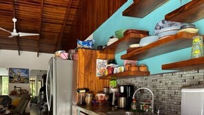 A kitchen with wooden cabinets, a stainless steel refrigerator, and a tiled backsplash.