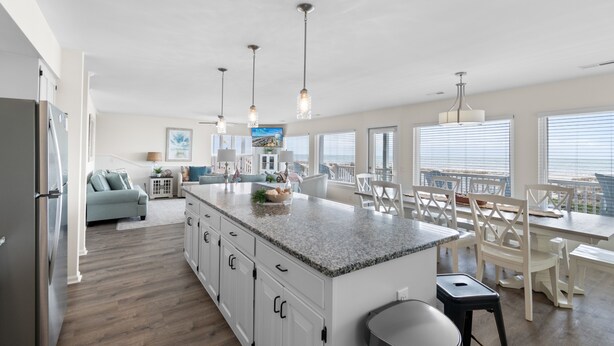A modern kitchen with a large island, white cabinetry, and pendant lighting. - "Good Times and Tan Lines " - Luxury Oceanfront Home w/ Private Pool, 6 Bedrooms / 5 Bathrooms (Holden Beach)