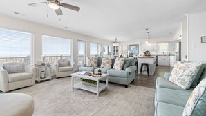 A spacious living area with a sofa, armchairs, a coffee table, and a ceiling fan. - "Good Times and Tan Lines " - Luxury Oceanfront Home w/ Private Pool, 6 Bedrooms / 5 Bathrooms (Holden Beach)