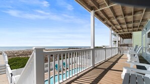 A wooden deck with a pool, chairs, and a view of the beach. - "Good Times and Tan Lines " - Luxury Oceanfront Home w/ Private Pool, 6 Bedrooms / 5 Bathrooms (Holden Beach)