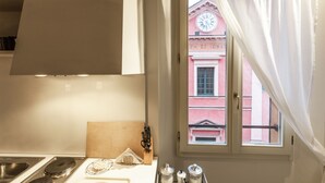 Una cocina con ventana, un lavamanos y una tabla de cortar de madera.