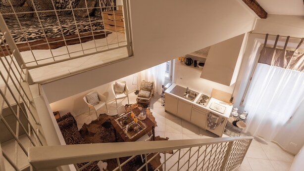 Un interior con varios niveles, que incluye un comedor, cocina y zona de estar.
