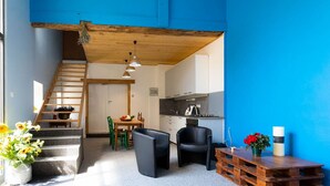 Un espacio habitable moderno con una escalera, una zona de comedor y una cocina.