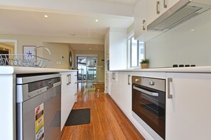 A modern kitchen with stainless steel appliances, a dishwasher, and a built-in oven.