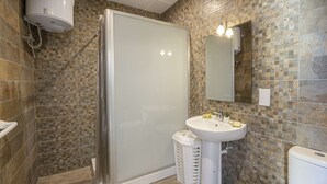 Un baño con ducha, inodoro y lavamanos.