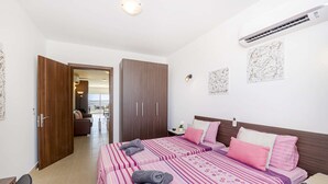 Un dormitorio con dos camas, un armario y un balcón.