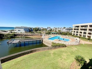 Um resort com piscina, um píer e vista para o oceano.