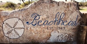 Une plaque de pierre sur laquelle sont gravés les mots « Beachhead » et « Fondée en 1969 ».