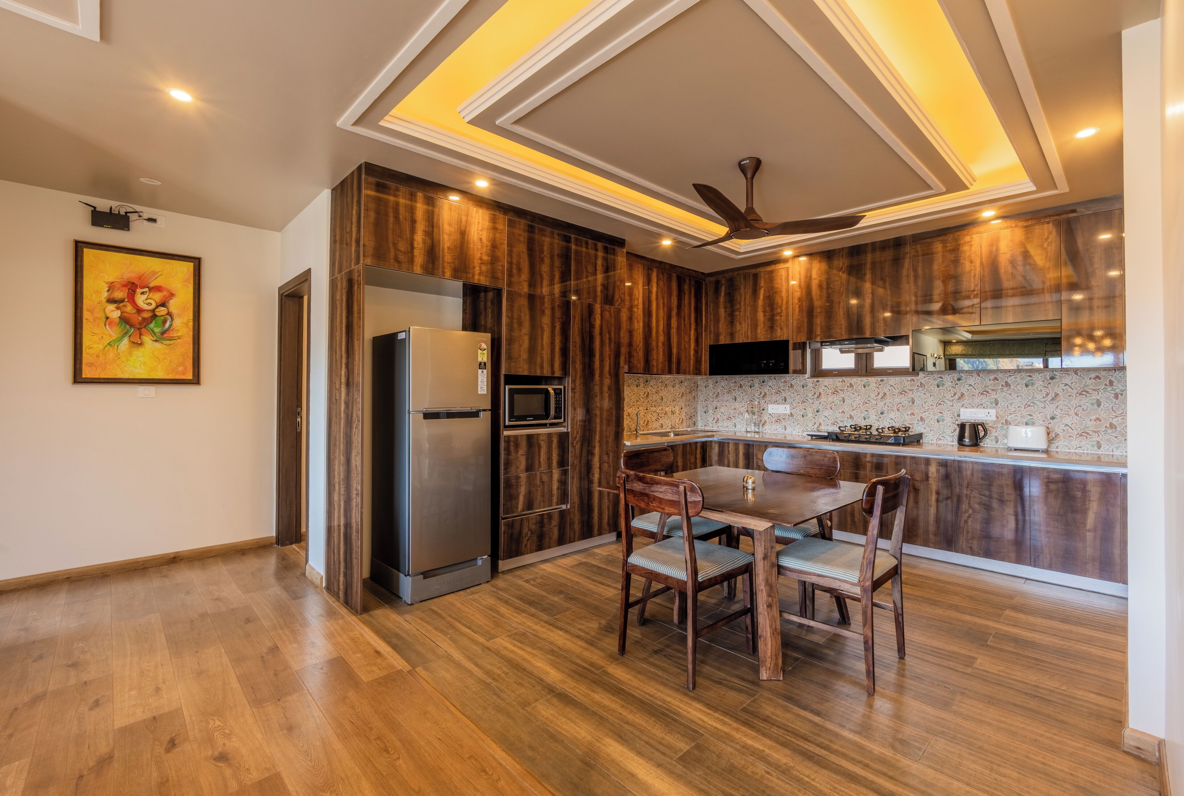 A modern kitchen with wooden cabinets, a built-in oven, and a dining area with a table and chairs.