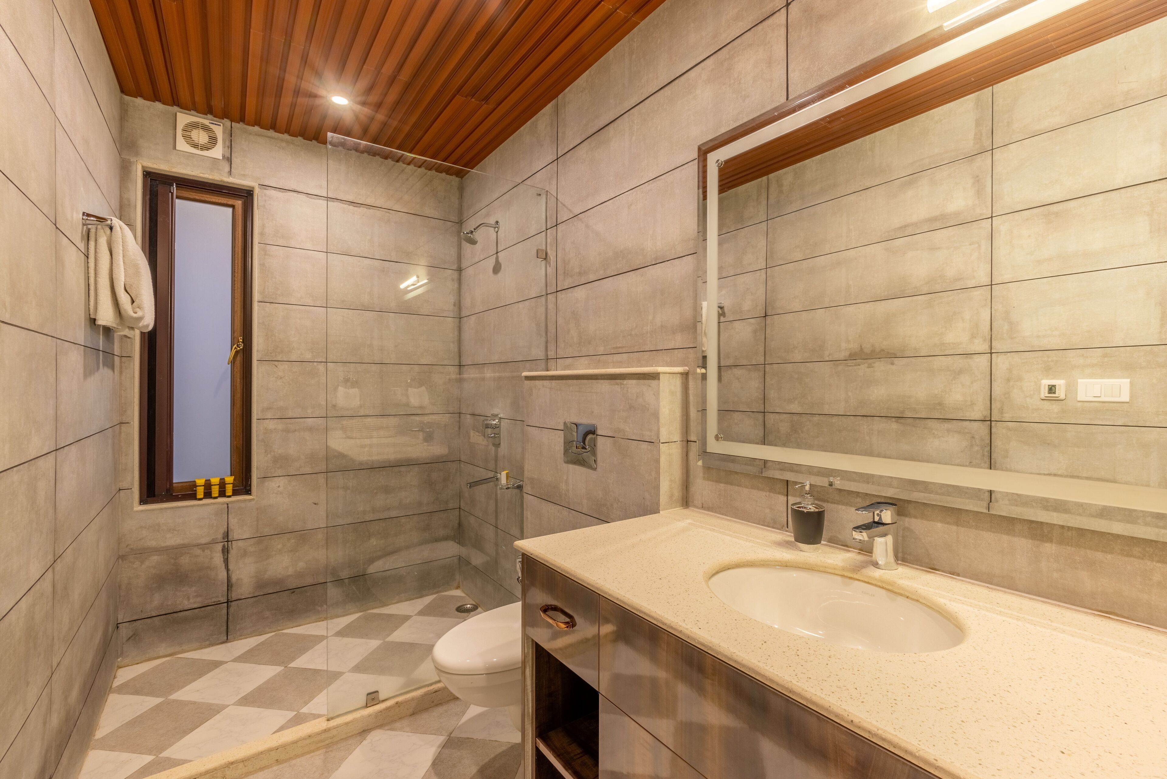 A modern bathroom with a large mirror, a sink, and a shower.