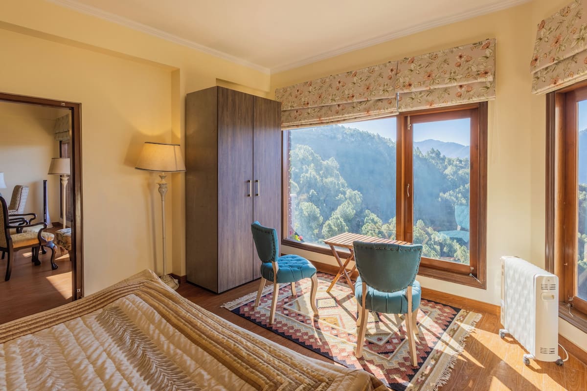 A room with a large window, a bed, a desk, and a chair.