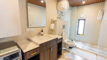 Un baño con lavamanos, inodoro y zona de ducha.