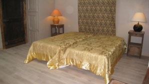 Een kamer met een bed, twee nachtkastjes, een deur en een behang met een patroon.