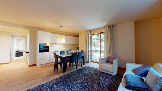 A modern apartment with a kitchen, dining area, and living room. - Modern 3½ room flat on the ground floor, approx. (Madulain)