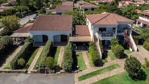 A residential area with terracotta-roofed houses, a central courtyard with a fountain, and a mountainous backdrop. - One bedroom apartment (4 people) - Le Dimore di Budoni (Budoni)