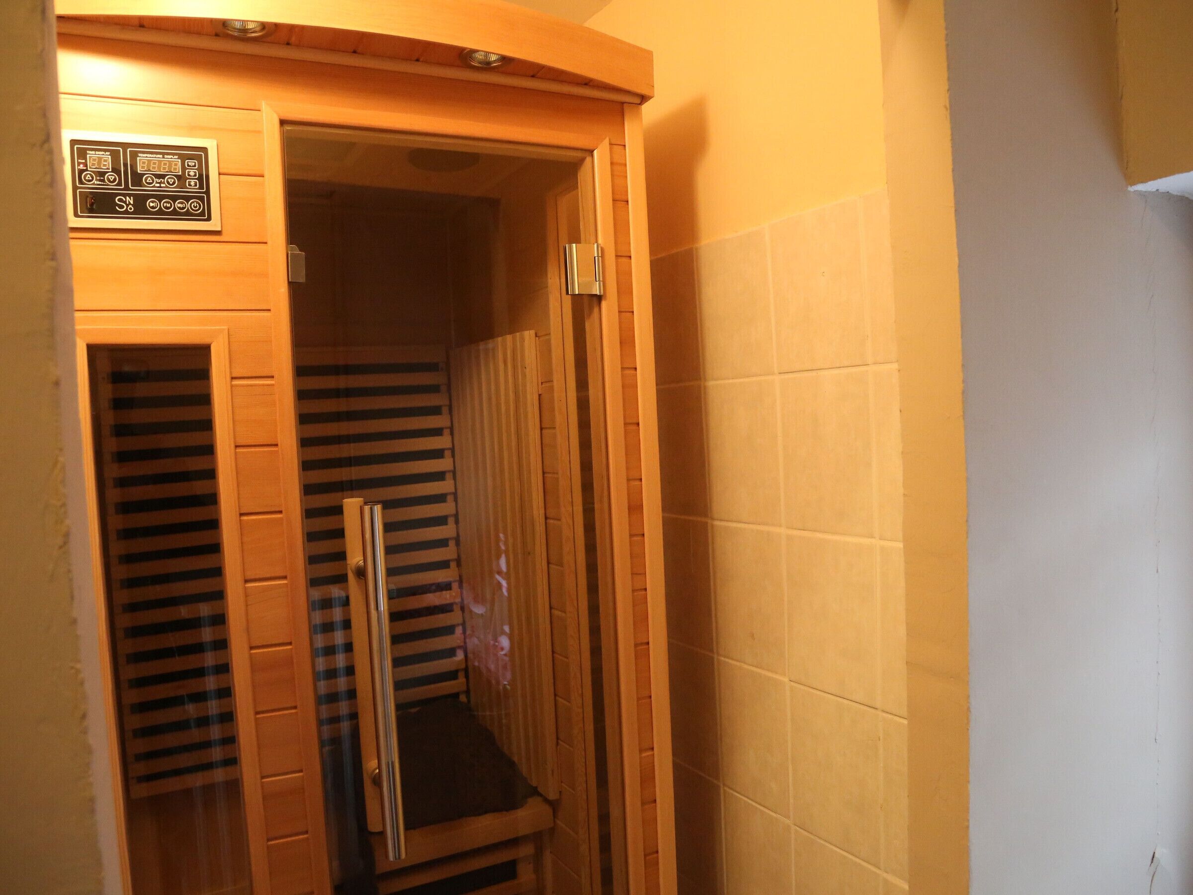A wooden elevator with a control panel and a metal handrail.