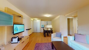 A modern apartment with a living room, dining area, and kitchenette. - Modern 3½ room flat on the ground floor, approx. (Madulain)