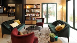 Una sala de estar moderna con dos sofás, una mesa de centro y una estantería.
