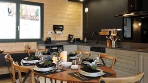 Una cocina moderna con armarios de madera, horno empotrado y un comedor listo para una comida.