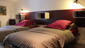 A double bed with a wooden frame, two bedside tables, and a wall-mounted shelf.