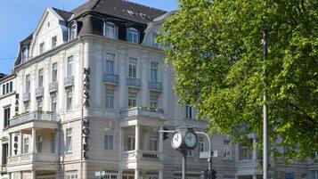 Un edificio histórico con un reloj, balcones y un letrero que dice