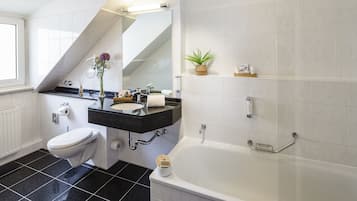 A modern bathroom with a toilet, sink, and bathtub.