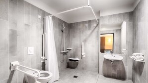 A modern bathroom with a toilet, shower, and sink. - B&B Hotel Rostock-Hafen (Rostock)