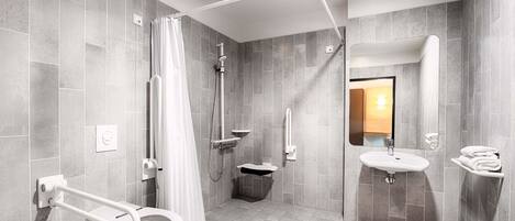 A modern bathroom with a toilet, shower, and sink.