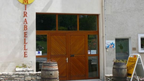 A building with a sign reading "Maison de la MIRABELLE" and a large wooden door. - Charming 19th Century House in Mirabelle Country with Terrace and BBQ (Rozelieures)