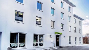 Un edificio moderno con múltiples ventanas y una zona de recepción.