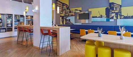 A modern interior with a bar area, seating, and a mural.