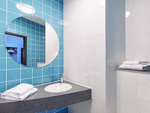 Un baño con lavabo, espejo y barra para toallas.