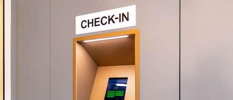 A check-in kiosk with a digital screen, keypad, and card reader.