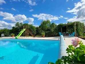 Ein Swimmingpool mit Rutsche und einer Holzkonstruktion.