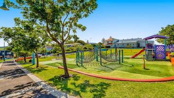 A playground with climbing structures, a slide, and a covered play area.