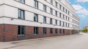 Een modern gebouw met veel ramen en een gevel van baksteen.