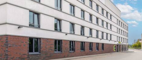 A modern building with multiple windows and a brick base.
