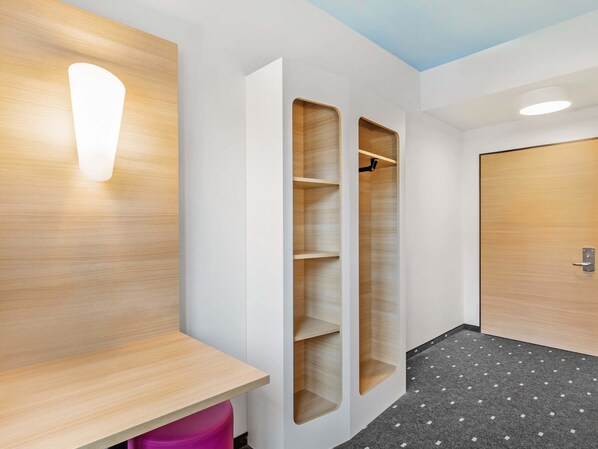 Un baño moderno con tocador de madera, zona de ducha y puerta con manija.