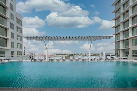Una piscina al aire libre, camas de piscina gratis, sombrillas