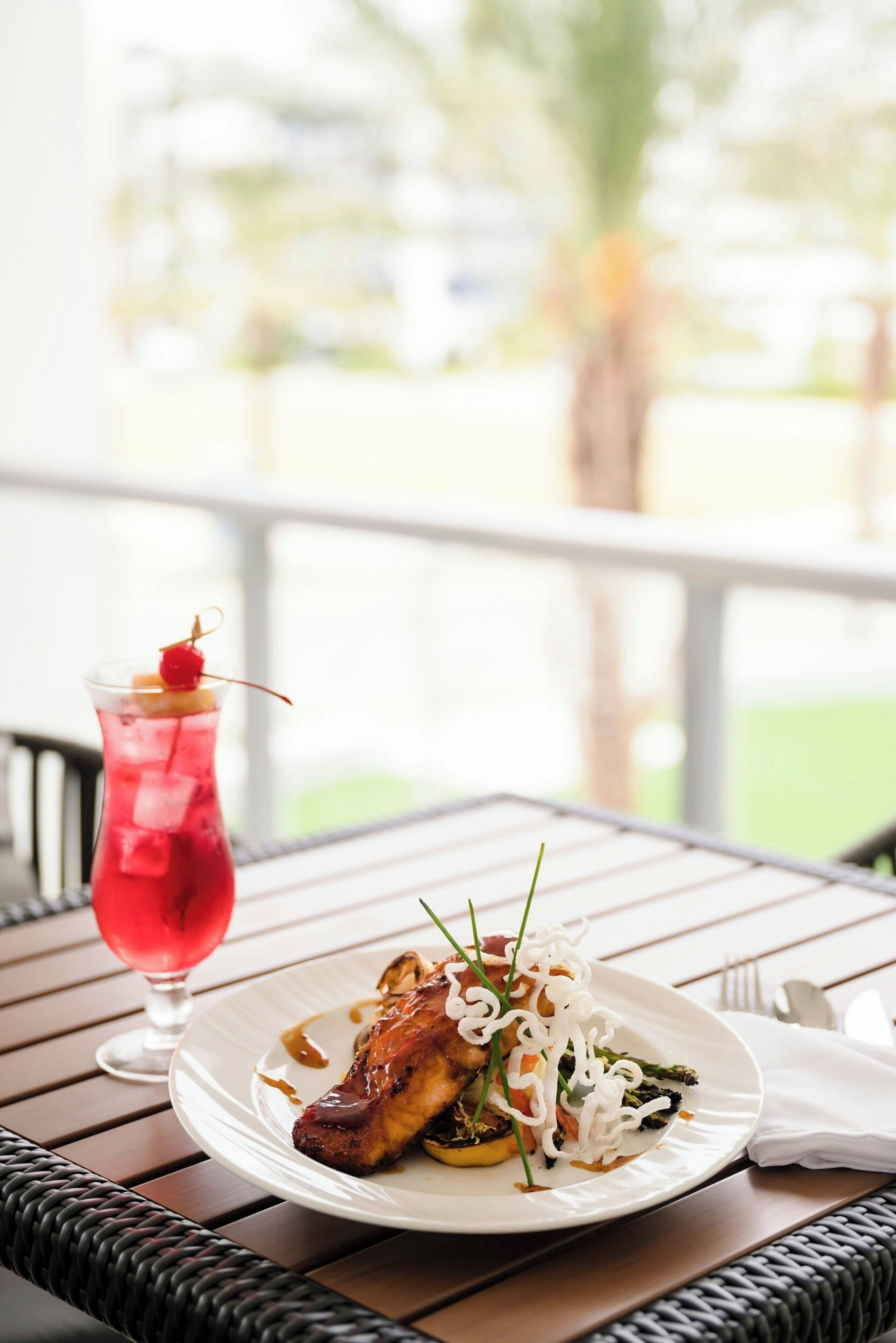 A dining table with a plate of food and a drink.