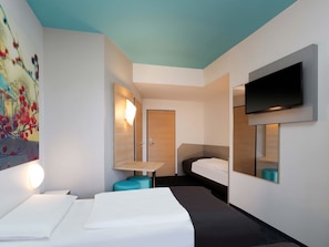 A modern hotel room with a bed, a desk, a TV, and a painting on the wall. - B&B Hotel Potsdam (Potsdam)