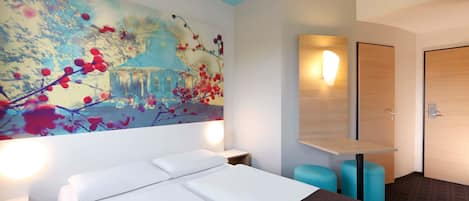 Habitación de hotel con una cama grande, televisor montado en la pared, mesita de noche y puerta con interruptor de luz.