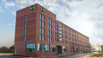 A modern red brick building with large windows and a sign reading "B&B HOTELS".