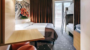 A hotel room with a bed, a desk, a chair, a painting, and a view of the outside. - B&B Hotel Bremen-Überseestadt (Bremen)