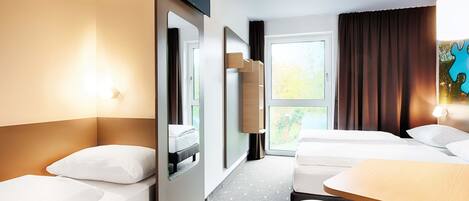 Een hotelkamer met twee bedden, een bureau, een televisie en een raam met gordijnen.