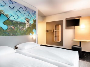 A hotel room with two beds, a wall-mounted TV, a wooden shelf, and a painting of a castle. - B&B Hotel Ravensburg (Ravensburg)