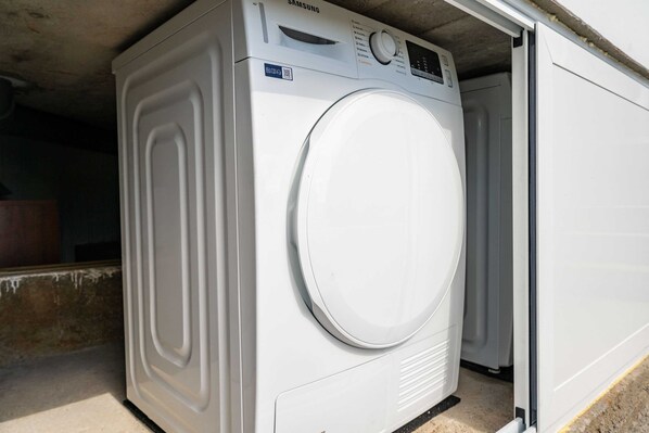 Un lave-linge Samsung blanc, doté d’un panneau de commande et d’une porte.