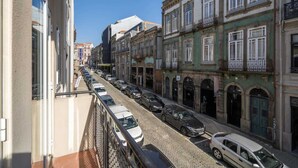 A street view with parked cars and buildings with balconies. - Colorful Bright Flat w/ Balcony by HostWise (Porto)