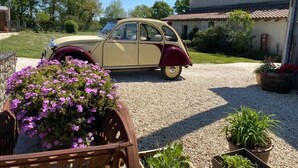 A vintage car parked in a driveway with a house in the background. - Peaceful Countryside Gite with private pool near Aubeterre (Laprade)